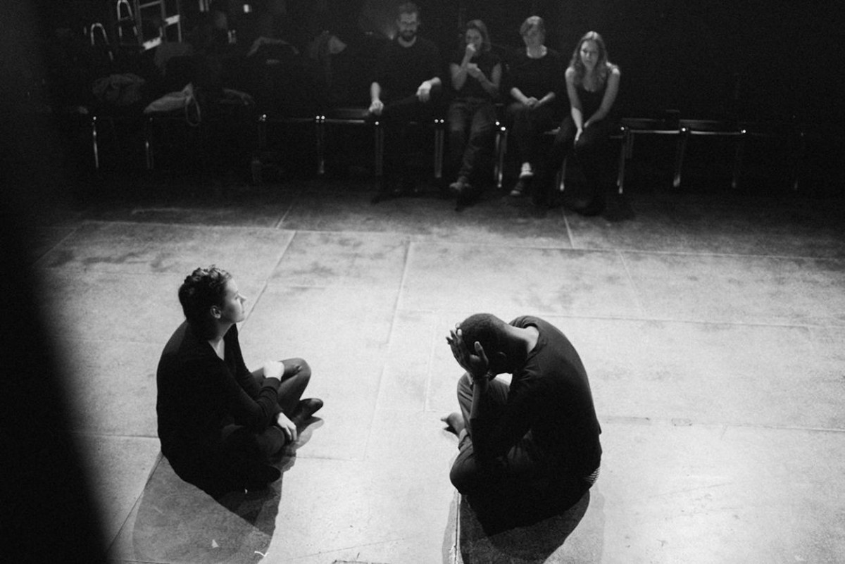 Zwei Studenten sitzen bei einer Theaterprobe auf einer Bühne