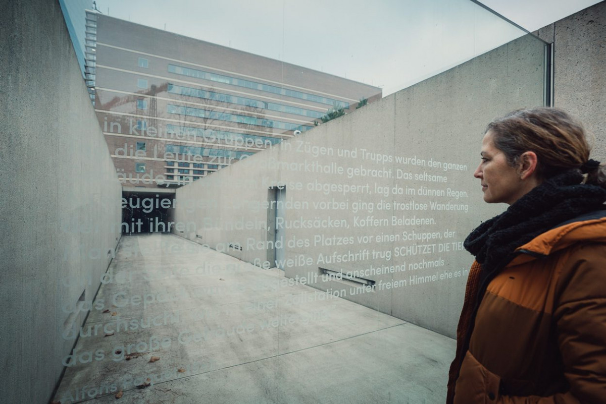 Susanne Buckley-Zistel liest eine Gedenktafel der Erinnerungsstätte an der Frankfurter Großmarkthalle
