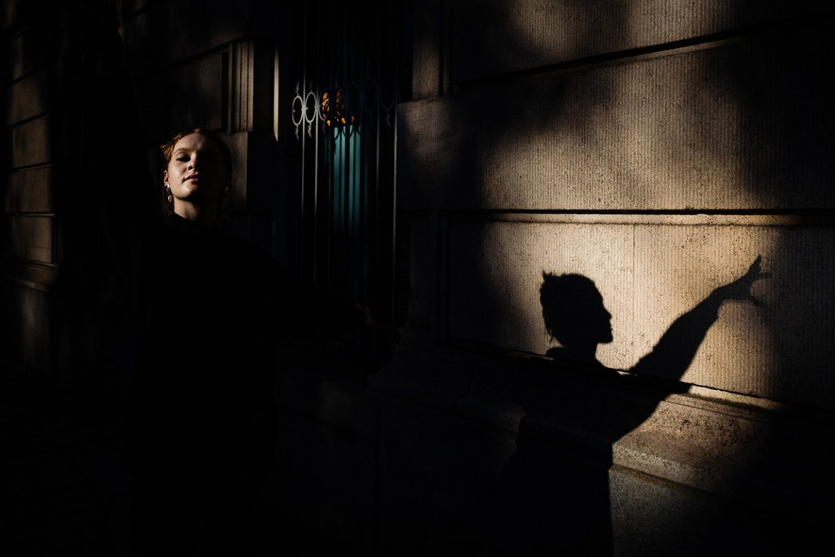 Tänzerin Mirjam Motzke wirft ihren Schatten an eine Hauswand.