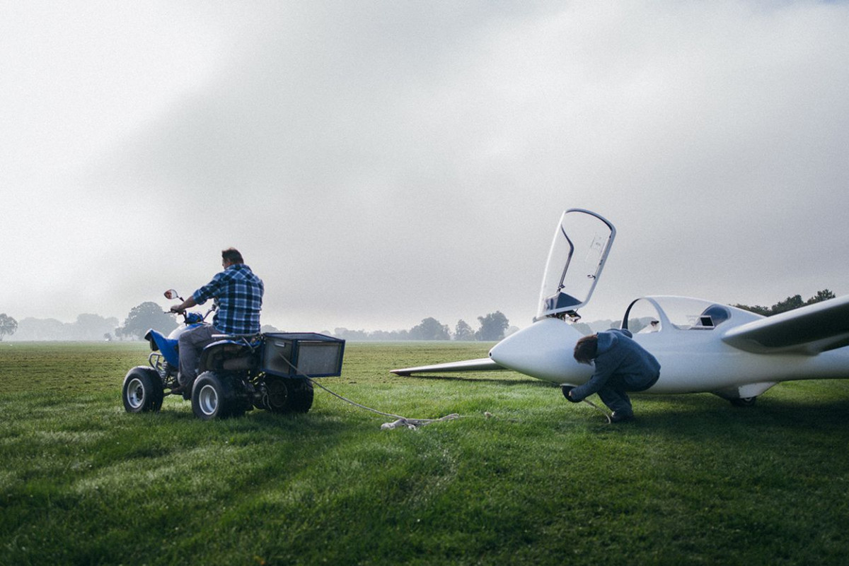 Eine Person befestigt ein Abschleppseil an einem Segelflugzeug