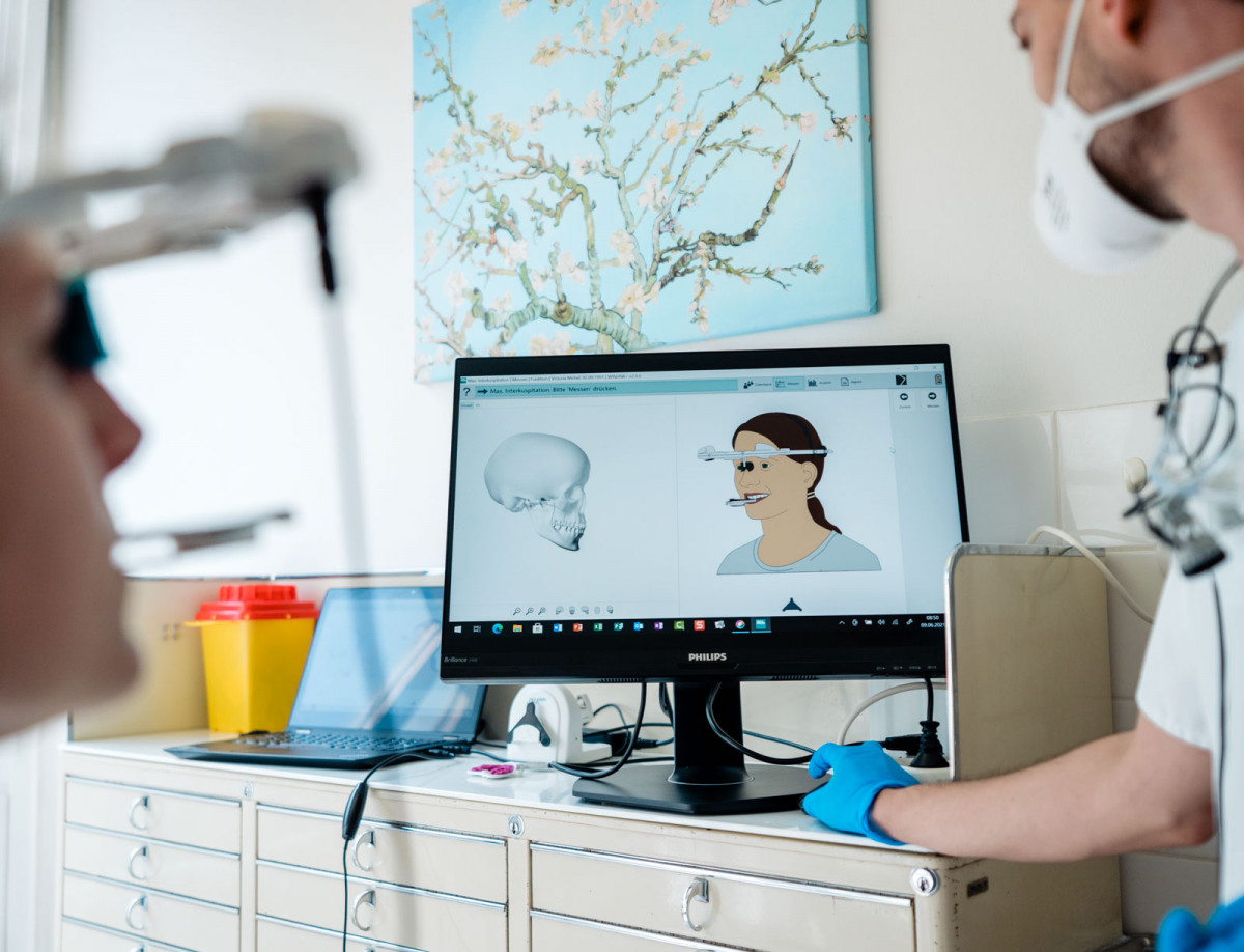 Studierende betrachten zahnmedizinische Illustrationen an einem Bildschirm.
