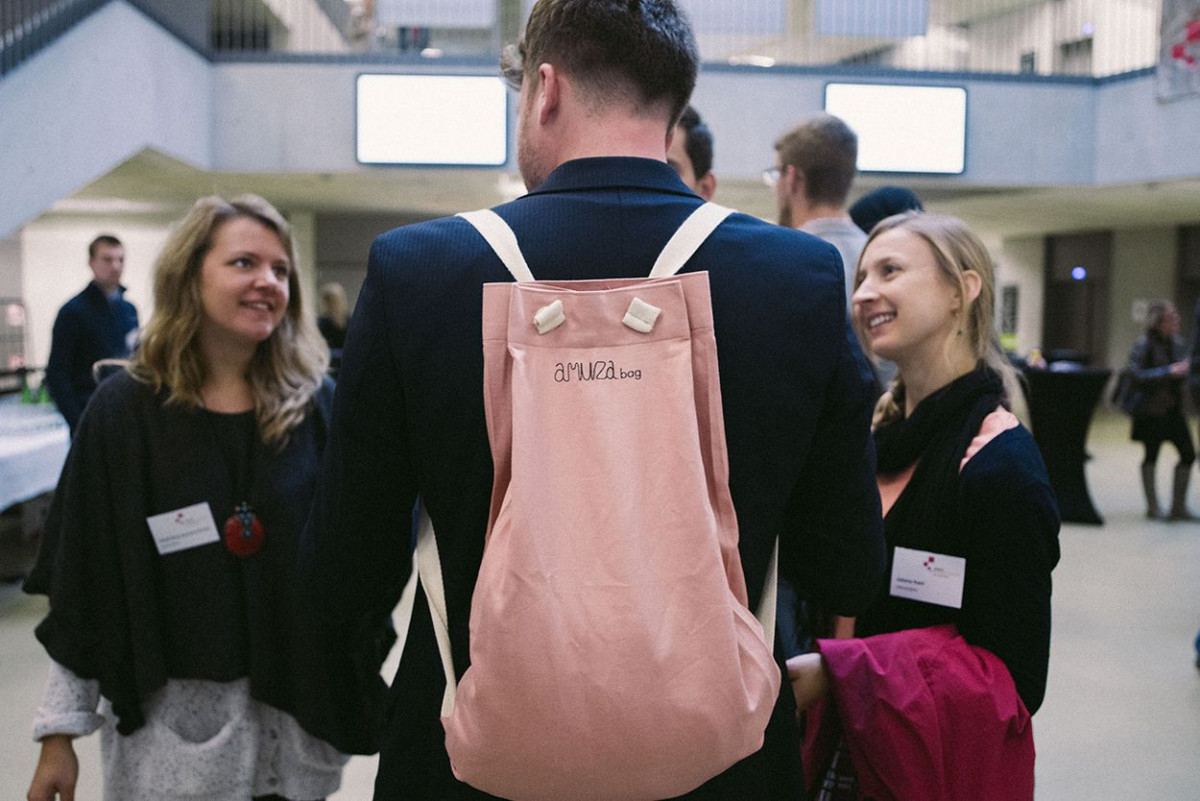 Gruppe von Studierenden mit einem jungen Mann, der eine rosafarbene Amuza Bag trägt