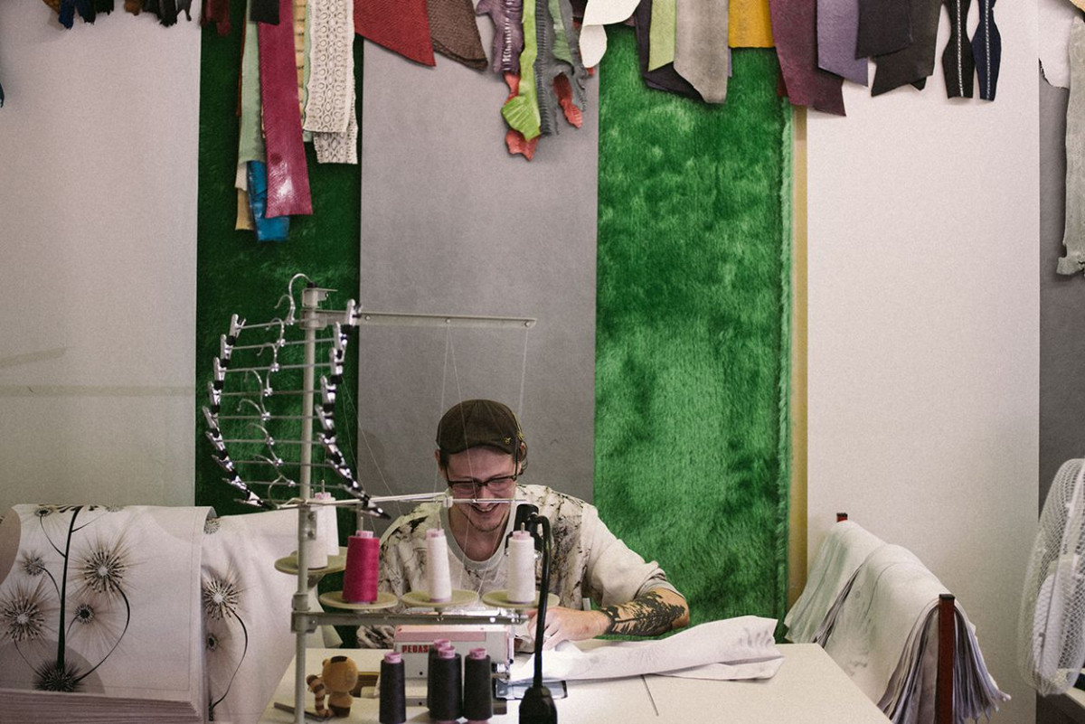 Ein junger Mann arbeitet in einem Atelier an einer Nähmaschine