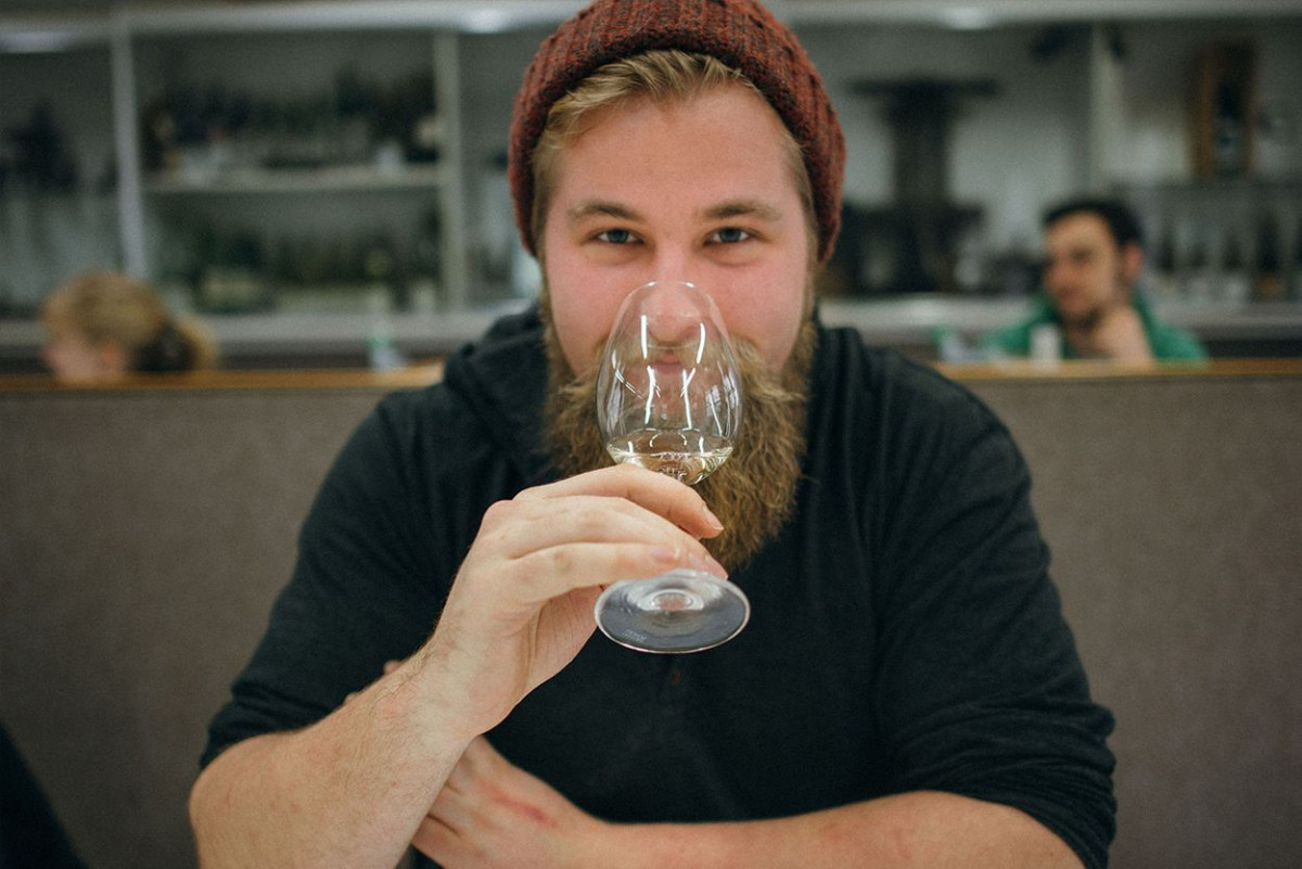 Ein junger Mann probiert einen Weißwein