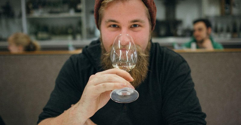 Ein junger Mann probiert einen Weißwein