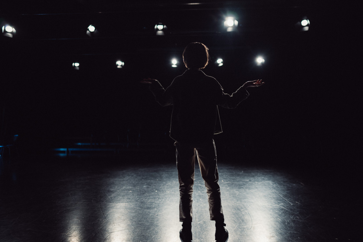 Schauspielstudentin Fenna steht im Gegenlicht der Scheinwerfer auf der Probebühne.