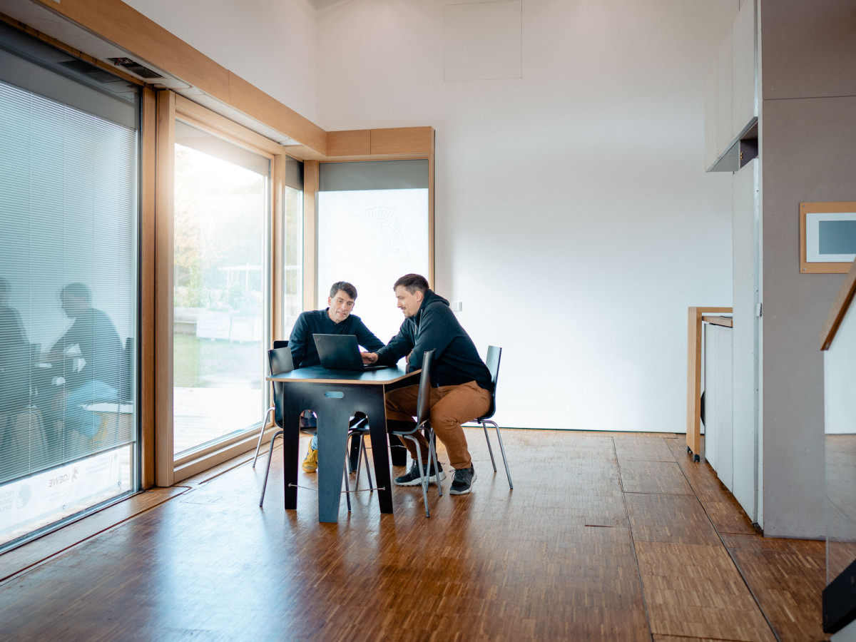 Martin Pietsch und Dr.-Ing. Joachim Schulze sitzen im preisgekrönten Solar-Decathlon-Haus der TU Darmstadt.