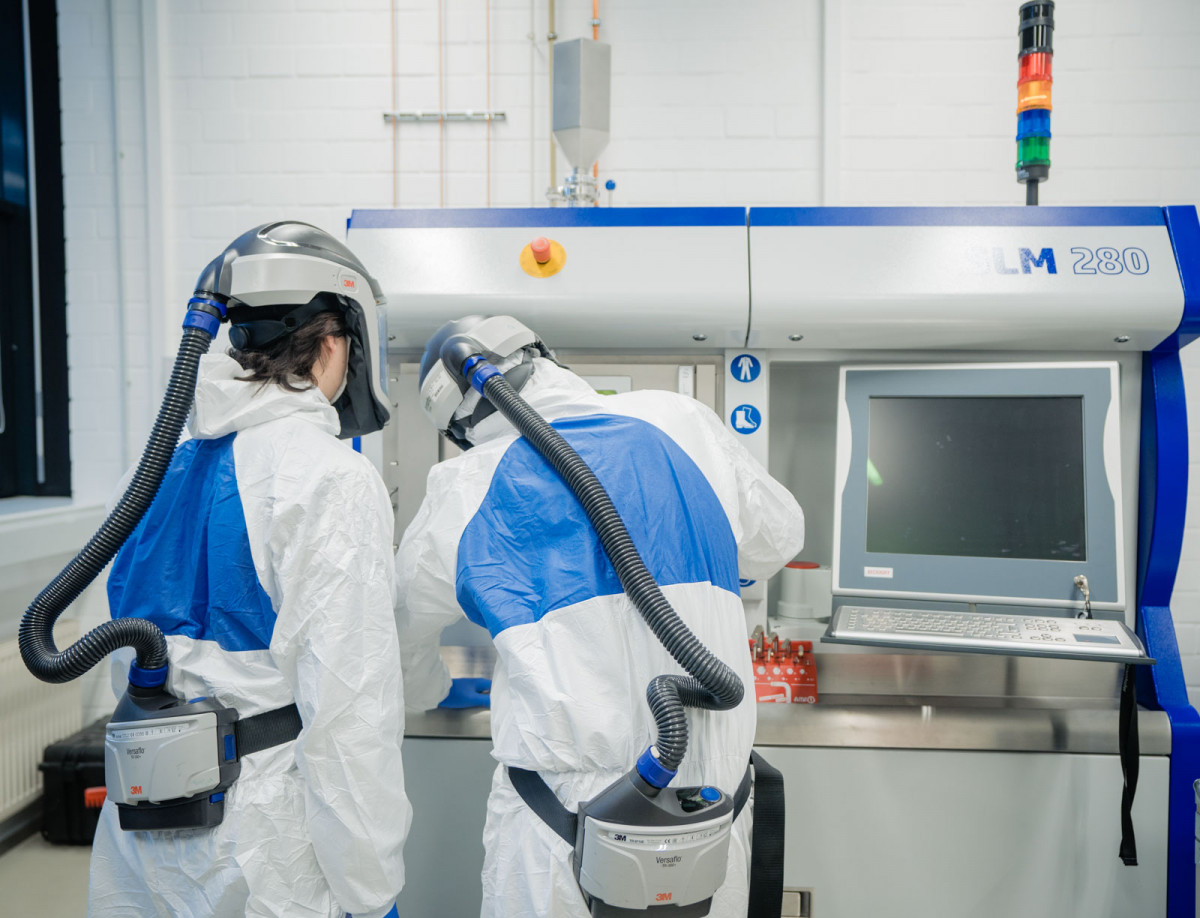 Studierende bedienen einen Metalldrucker.