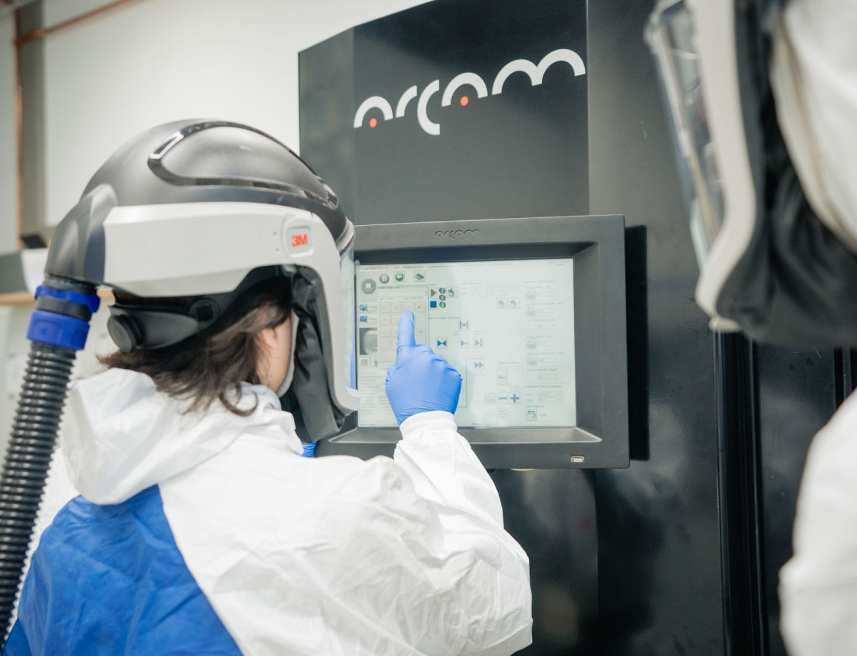 Studierende bedienen einen Metalldrucker.