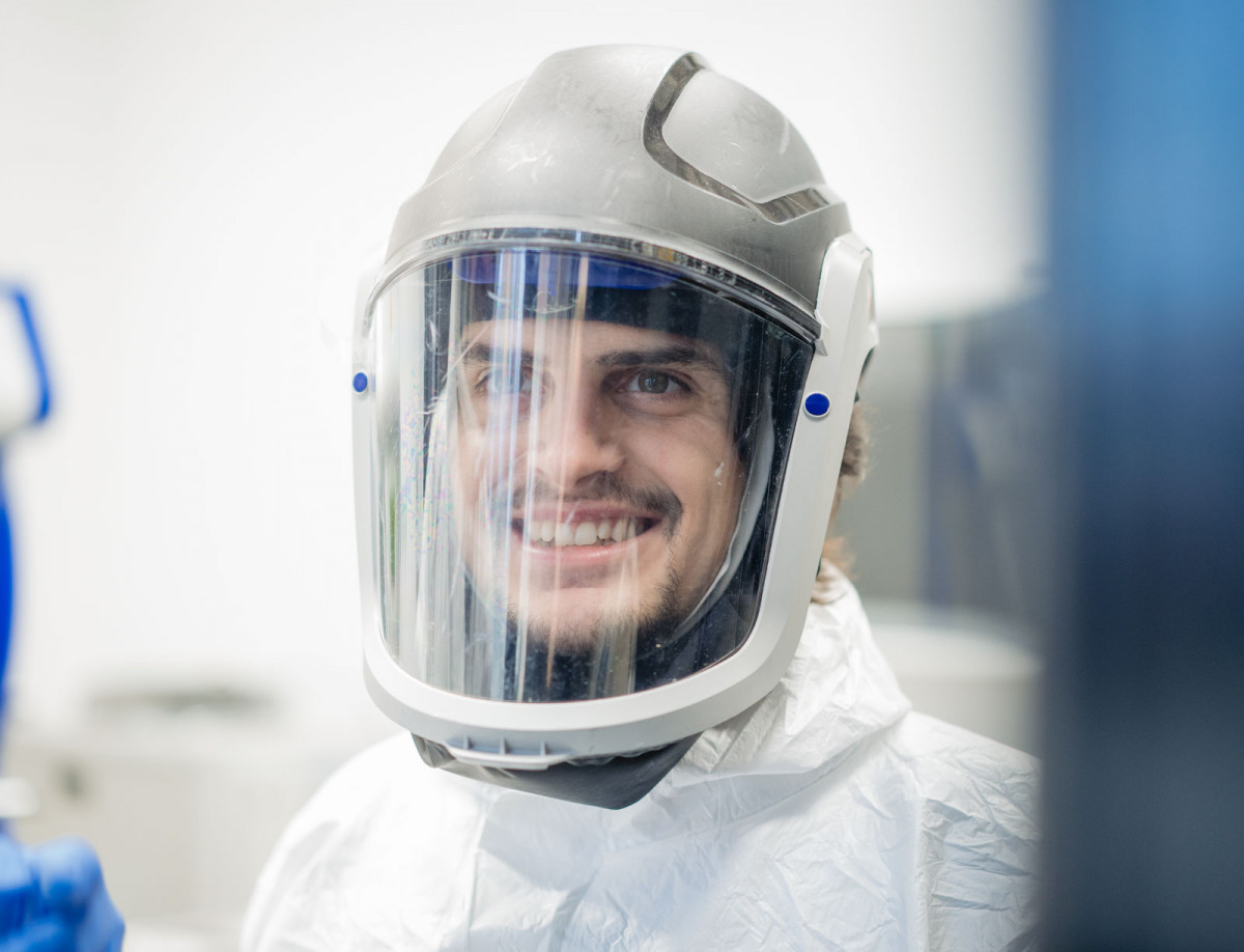 Tizian Arold vom Fachgebiet Metallische Werkstoffe in Schutzkleidung in der Maschinenhalle.