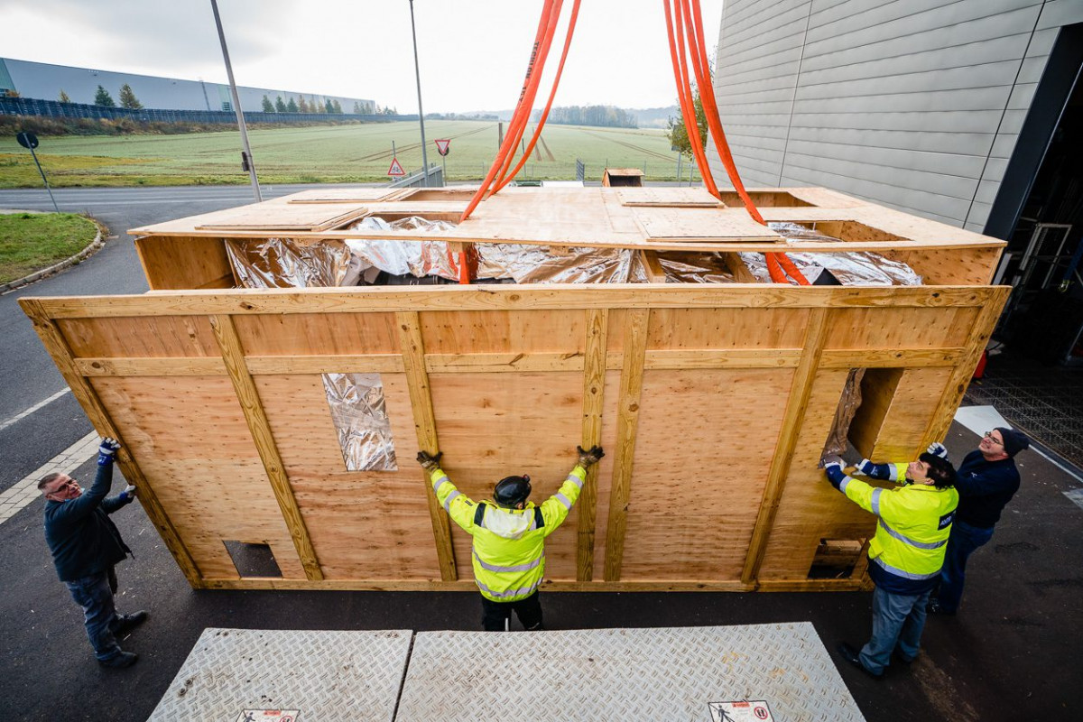 Arbeiter beim Öffnen der Holzkiste, in der die neue Thixomolding-Maschine geliefert wurde.