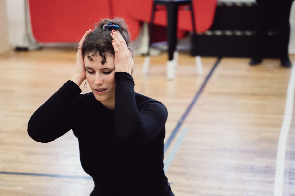 Gesamgsstudentin Alina sitzt in tragischer Pose während einer Probe am Boden.