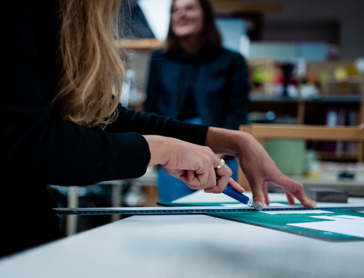 Annika schneidet Papier im Werkraum der Kunsthochschule Kassel.