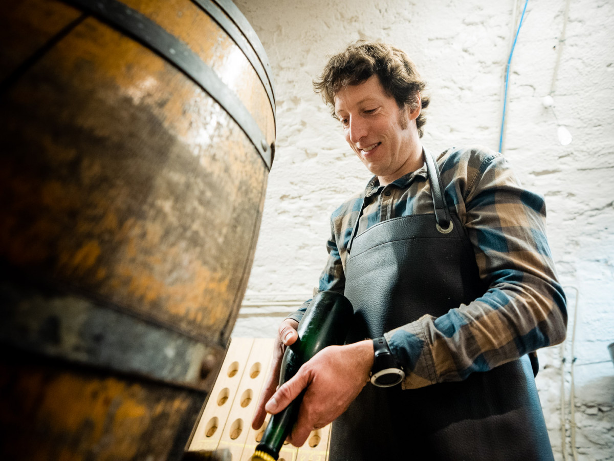 Dr. Matthias Schmitt von der Hochschule Geisenheim University öffnet eine Flasche.