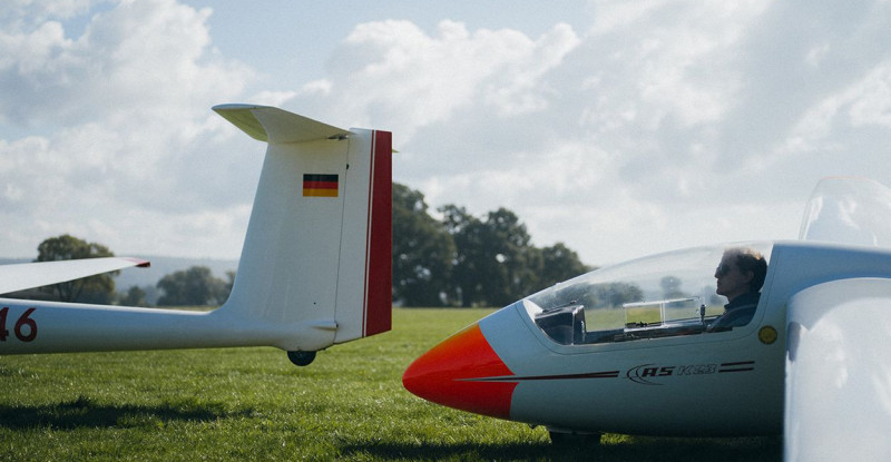 Ein junger Mann sitzt in einem stehenden Segelflugzeug