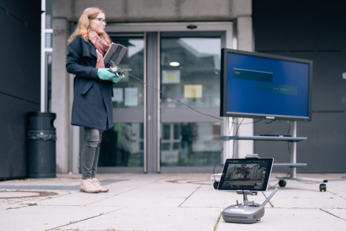 Eine Studentin bedient mit einem Controller einen Computer.