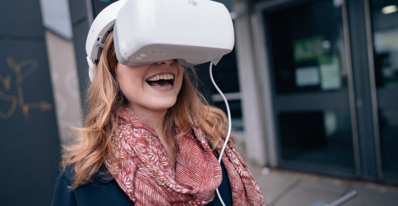 Eine Studentin testet begeistert eine 3D-Brille.