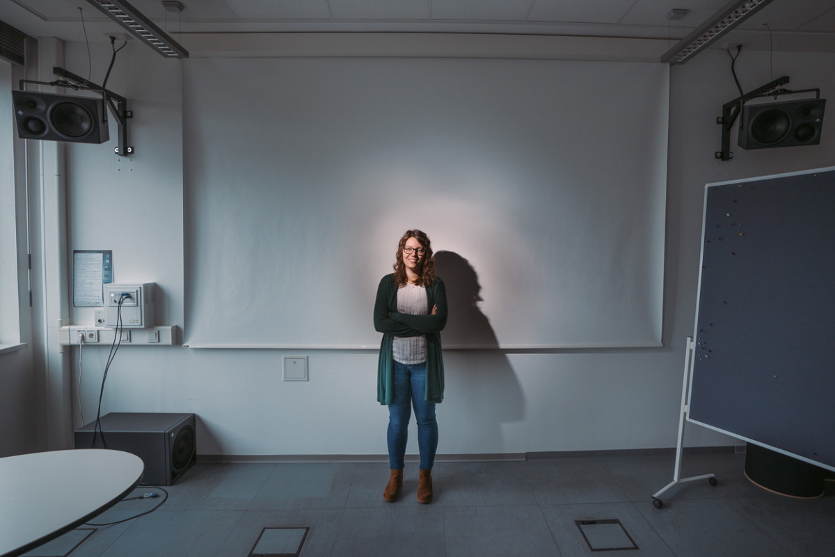 Eine Studentin steht vor einer leeren Leinwand.