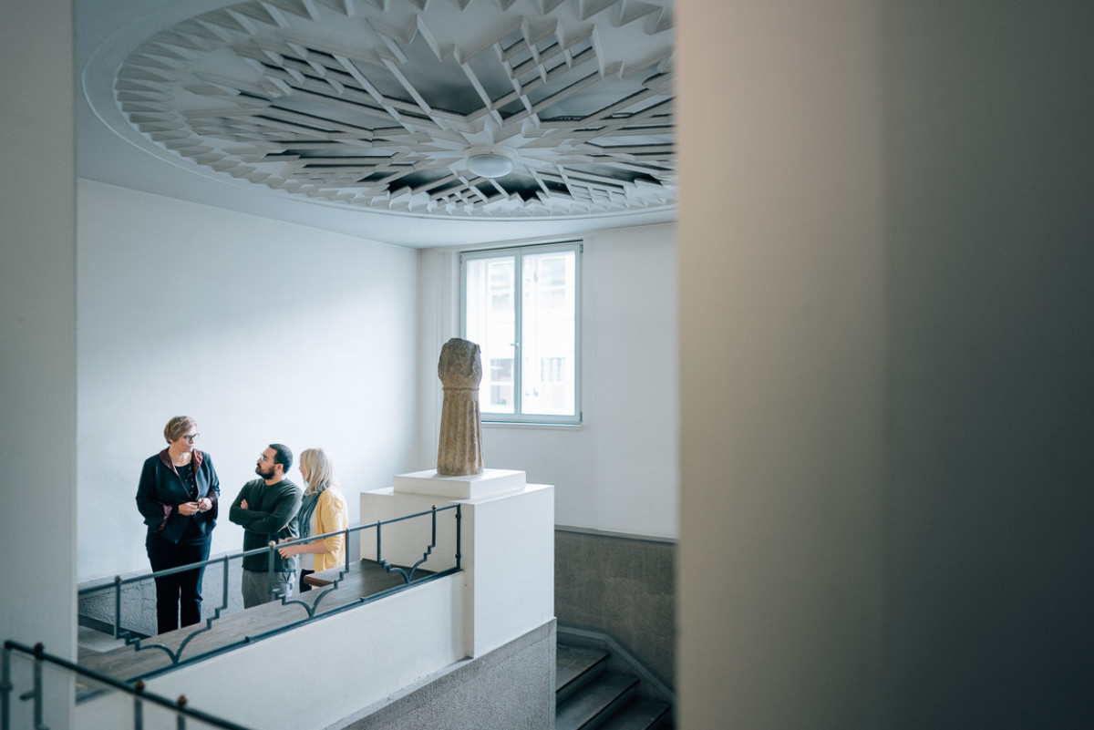 Professor Böhlendorf-Arslan mit den Studierenden Hüseyin Çinarlik und Alieda Halbersmah im Treppenhaus vor dem Archiv.