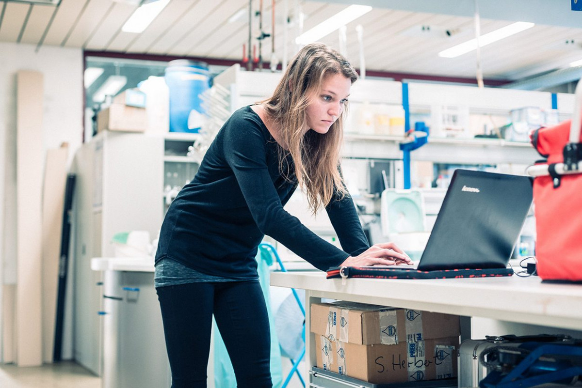 Eine junge Frau arbeitet an einem Laptop