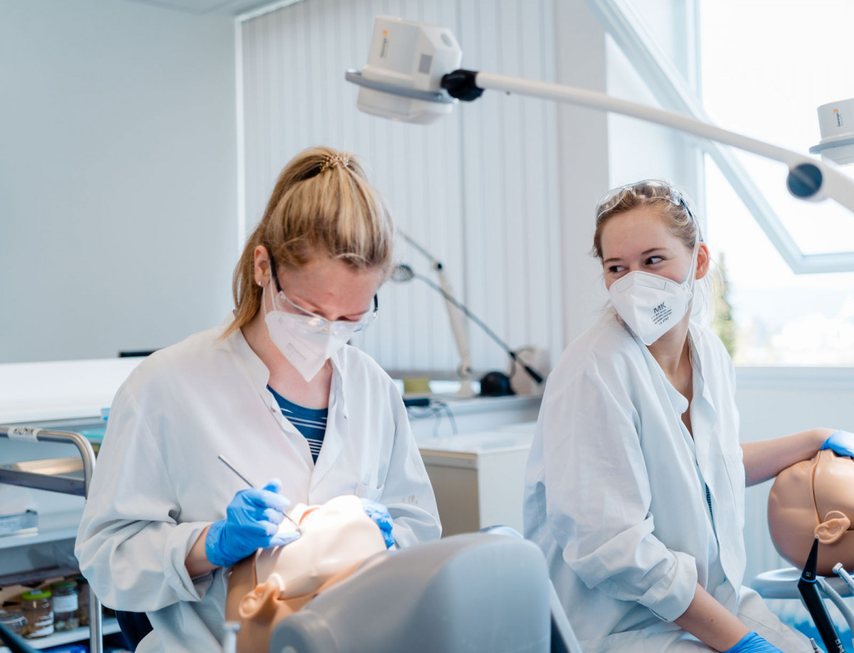 Zwei Studentinnen behandeln Patientensimulatoren im zahnmedizinischen Labor.