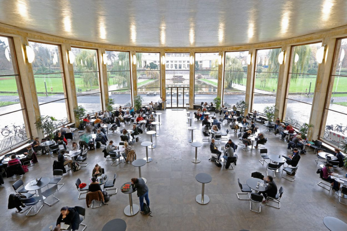 Gruppen von Studierenden sitzen an runden Tischen in der Eisenhauer Rotunde der Goethe-Universität Frankfurt